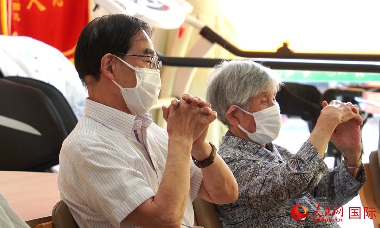 日本にある介護施設で手の運動をする清野明さん(写真左)と若生豊美さん(写真右、撮影・許可)。